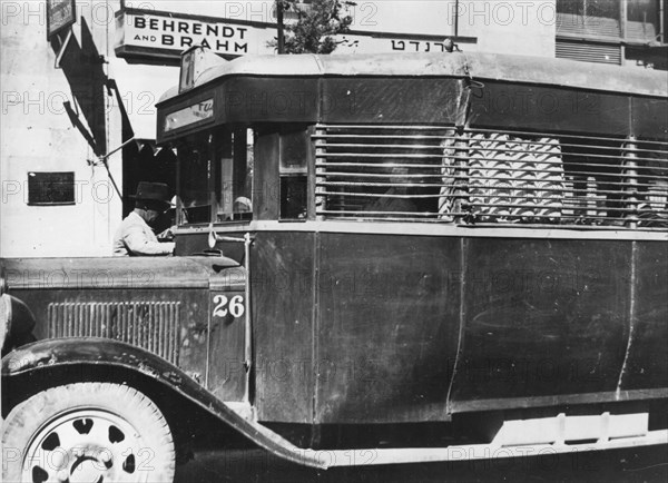 A Jewish bus in Palestine with protective covering on the outside to protect bus riders.