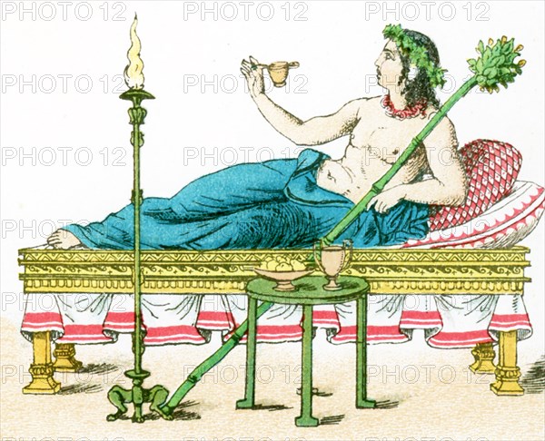 The illustration here shows an ancient Greek couch with table and candelabrum, and a flaming torch. The illustration dates to 1882.