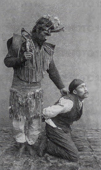 Shaman holding a man on his knees, 1890, Alaska, Historic, digitally restored reproduction from an original of the period.