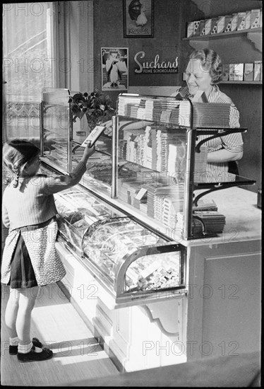 Girl buying chocolate; around 1943.