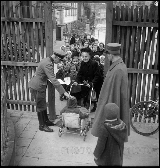 Border officials control identity papers of a woman that accompanies the children.