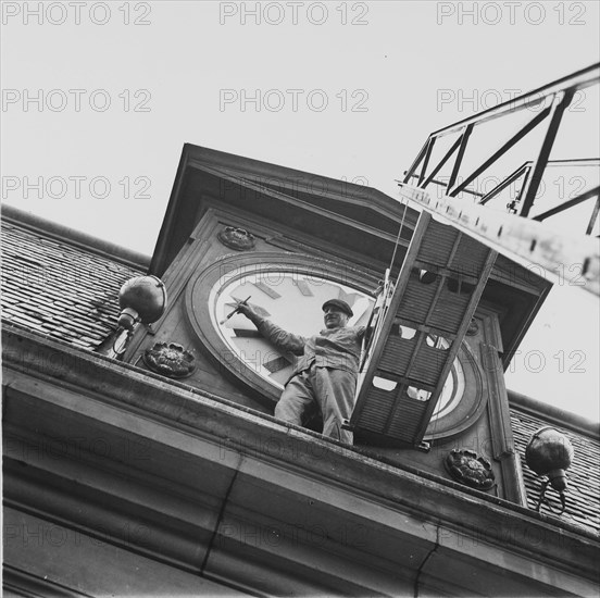 Blackout: man painting numerals of church clock with luminous paint, ca. 1943.