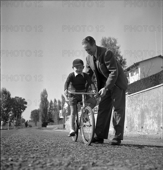 Emmanuel de Graffenried and son Leo on his bicycle, 1950.