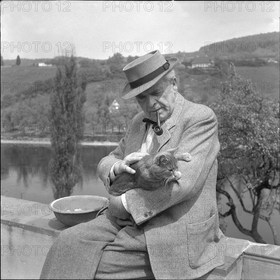 Carl Roesch, painter and sculptor, with a cat, ca. 1959.