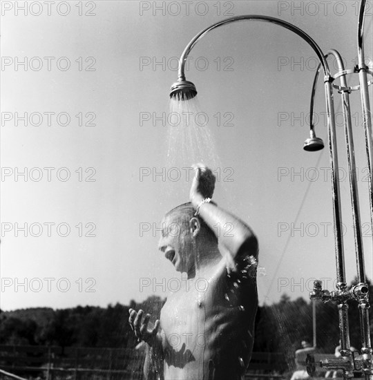 Young man taking a shower in the outdoor-swimmingpool Dolder in circa 1950