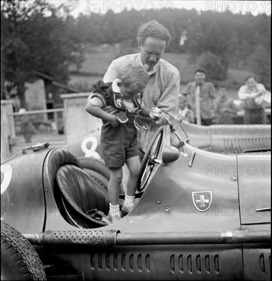 Emmanuel de Graffenried and son Leo in racing car, 1950