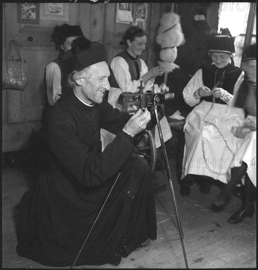 Pastor taking photos from spinning women in Valais, ca. 1950