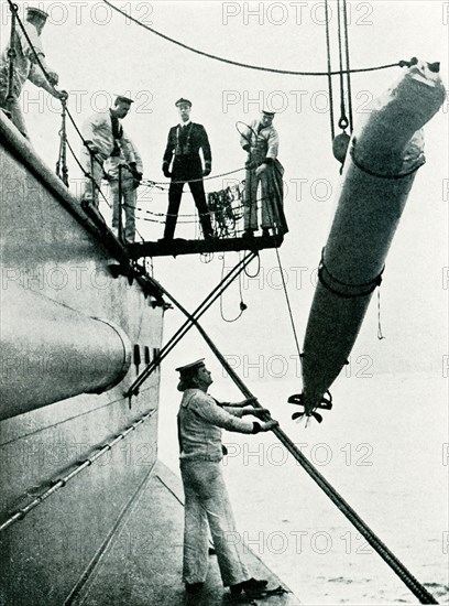 This photo from world war I shows a practice torpedo being hoisted over the side of a British ship.