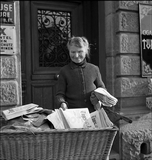 Newspaper home delivery by Mrs. Straub, on duty for 50 years; Zurich ca,. 1950.