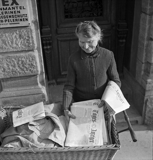 Newspaper home delivery by Mrs. Straub, on duty for 50 years; Zurich ca,. 1950.