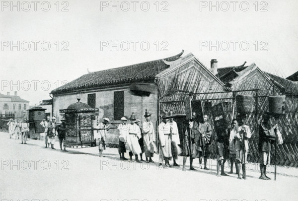 Wedding Procession in China. The caption of this 1900 photo reads:  “Wedding Procession.  Bride in sedan chair carried by several men In this air-tight affair she is locked up to be carried to where ceremony to take place No one allowed to see her during procession.”.