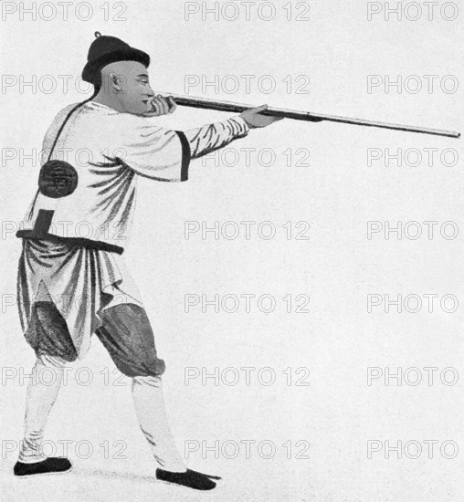 This illustration of a Chinese soldier, holding and aiming his gun, dates to 1900. The time period in China is the Boxer Rebellion, which was an uprising against foreigners in the country. The Chinese were fighting against British, Americans, Jpanerse and several other countries. Note his queue—traditional hairstyle at the time. It had been imposed on adult Chinese men in the 1600s during the Qing dynasty. The penalty for not doing so was death, as such an infraction of the rules was considered treason. After the fall of the Qing in the 1912, the rule did not apply. The tradition was to shave the temple and forehead every 10 days or so and keep the rest braided.