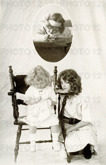 The caption for this 1917 image reads: 'Pleasant Pictures of Child Life.' It shows an older girl watching a young child do stitch work . In the inset above is a young child writing.