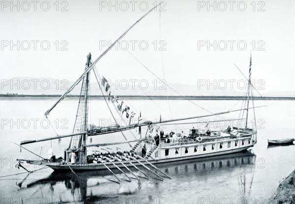 The caption on this 1903 image reads: “Dahabieh descending the Nile.” It appeared in the book History of Egypt by French Egyptologist Gaston Maspero. A dahabieh is a long light-draft houseboat used on the Nile that is lateen-rigged and is often propelled wholly or partly by engines.