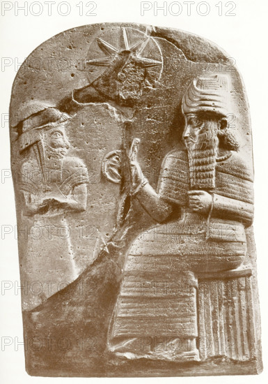 The sculpted figure at left is Hammurabi, standing before Shamash, the sun god and 'Lord of Judgment.'  The disk above and between the two figures represents a sun disk. Hammurabi was ruler of Babylon from 1792 to 1750 B.C. and is known for the set of laws called Hammurabi's Code, one of the first written law codes, that were inscribed below a similar scene on a black diorite stele that measured more than 8 feet in height.