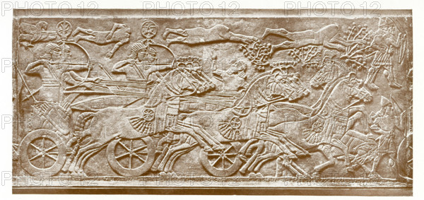 This marble slab shows the horse in warfare. The royal figure is Assyrian king Ashurnasirpal II (died c. 860 B.C.) and  his army is advancing against a besieged town. A battering ram is being drawn on a six-wheeled carriage. The slab is from  Ashurnasirpal II's N.W. palace in Nimrud (ancient Kalhu) in present-day Iraq. It is presently in the British Museum.