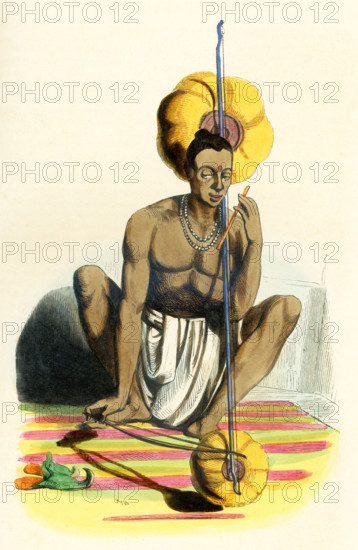 This 1840s illustration shows a Hindu man playing a pena, Pena, also known as Tingtelia, is a mono string instrument falling in the lute category, similar to some of the traditional Indian stringed musical instruments such as Ravanahatha, Ubo or the Kenda, found in various parts of the country.