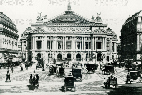 This photo dates to around 1902 and shows the Grand Opera House in Paris, France. The Palais Garnier (Garnier Palace or Opera Garnier) is a 1,979-seat opera house at the Place de l'Opera in the 9th arrondissement of Paris, France. It was built for the Paris Opera from 1861 to 1875 at the behest of Emperor Napoleon III. Initially referred to as ""le nouvel Opera de Paris"" (the new Paris Opera), it soon became known as the Palais Garnier, ""in acknowledgment of its extraordinary opulence"" and the architect Charles Garnier's plans and designs, which are representative of the Napoleon III style.