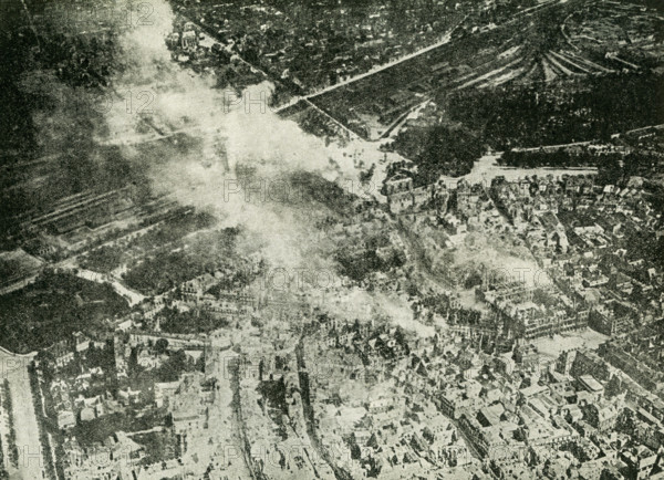 The caption reads: Remarkable photo of the Germans burning Reims, Incendiary shells can be seen falling, adding to the conflagration. This photo dates to World War I.