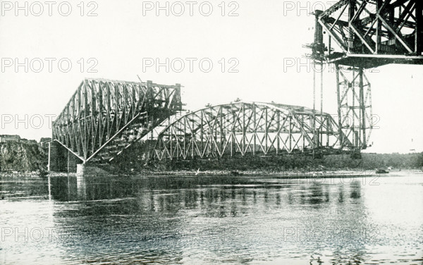 Giant Cantilever bridge which spans St Lawrence River at Quebec. The great cetner span, 640 feet long and weighing 5,600 tons, is being hposted into place to complete the structure. It was a similar span which fell in 1916, carrying 90 men to death. The completed bridge is the largest of its type in the world, It cost $16,876,000, is 3,239 feet long, 88 feet wide, and 163 feet high from the base of rail to high water level. It carries two railroad tracks, a driveway for vehicles, and two concrete foot paths.