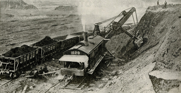 Open Pit Mine from which ore comes. Most of the iron ore mined in North American comes from the open pit mines of the Lake Superior region. The deposits are sometimes three hundred feet deep and seem almost inexhaustible. Here you see a stream shovel digging into the bank and loading the cars. One of these machines does more work than a thousand men could do with picks and shovels.