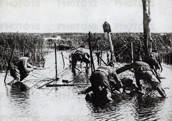 This photo dates to the First World War. The caption reads: Americans cutting wire entaglements prior to a drive.