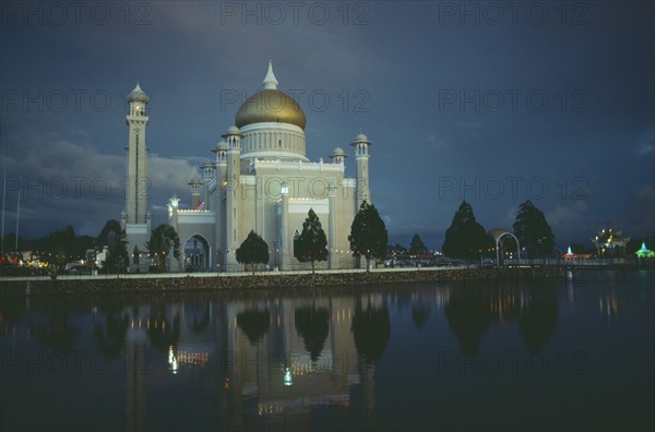 BRUNEI, Bandar Seri Begawan, "Omar Ali Saifuddin Mosque, exterior view reflected in water illuminated at dusk."
