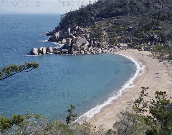 AUSTRALIA, Queensland, Magnetic Island, Arthur's Bay looking down onto  deserted beach with rocks at the far end