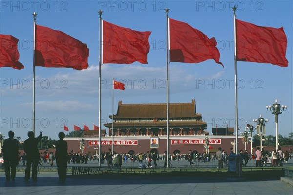 CHINA, Hebei, Beijing , Gate of Heavenly Peace entrance to the Forbidden City in Tiananmen Square behind red flags blowing in the wind