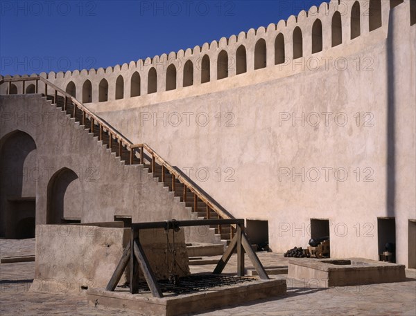 OMAN, Nizwa , Fort interior with cannons and cannon balls placed by the wall.