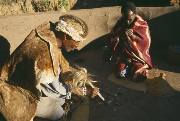 SOUTH AFRICA, Qwa-Qwa, Basotho Village, Basotho Cultural Village.  Local man consulting a Diviner using stones.