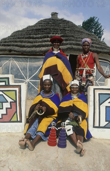 SOUTH AFRICA, KwaZulu Natal, Mpumalanga, Ndebele women in traditional dress outside the arts and crafts shop at White River near Middelburg