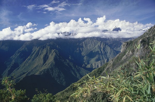 PERU, Cusco Department, Machu Picchu , The Inca trail mountain view from Machu Pichu with clouds covering the tops of the mountains