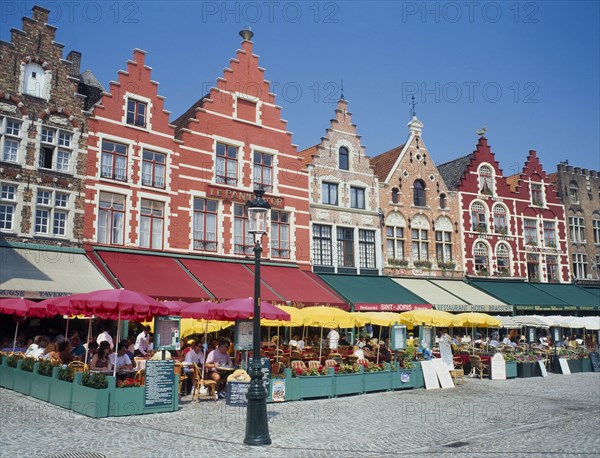 BELGIUM, West Flanders, Bruges, "The west side of the Main Square, Grote Markt, with outdoor restaurants and umbrellas "