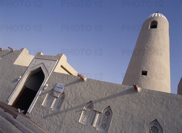 QATAR, Doha, Angled view of Small Mosque in the old souk area showing front entrance and minaret.