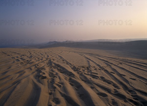 QATAR, South East, Desert, View over sand dunes at sunset near the Sealine Resort.