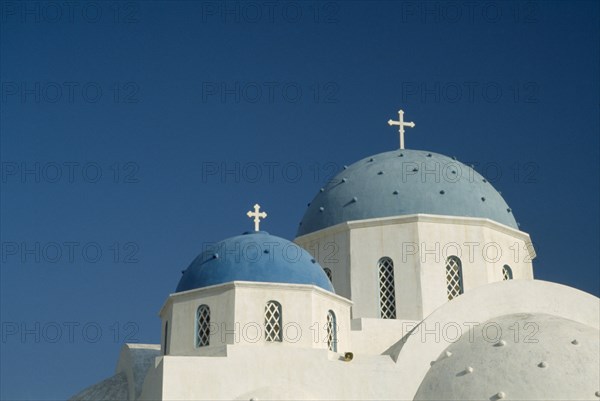 GREECE, Cyclades Islands, Santorini, Perissa.  Blue domed rooftops of white painted church.