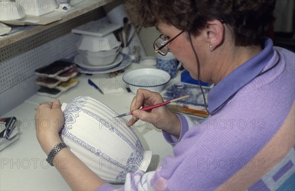HOLLAND, Industry, Delftware, Female worker painting design onto delftware vase.