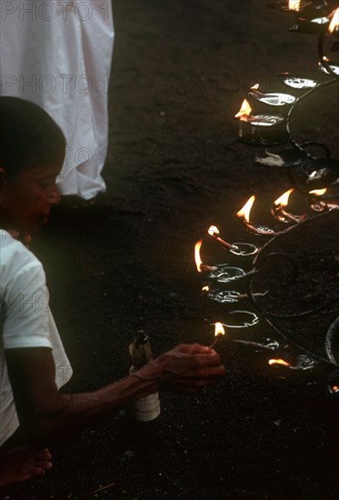 SRI LANKA, Anuradhapura, People lighting lamps during Wessac