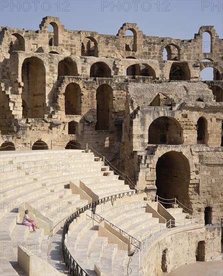 TUNISIA, El Djem, Roman Amphitheatre interior with a lone woman sitting on terraces