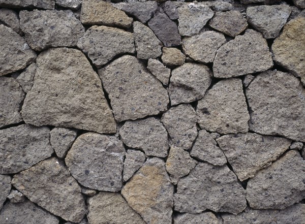 INDONESIA, Bali, Lovina, Detail of dry stone wall at Kalibukbuk