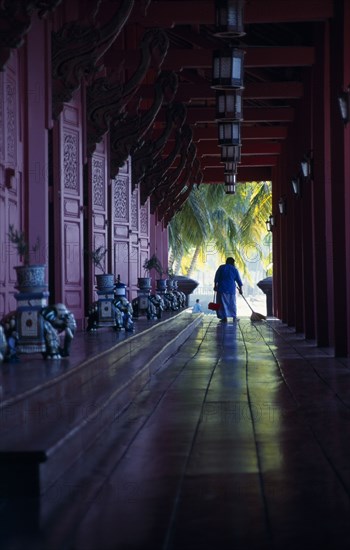 MALAYSIA, Kedah, Langkawi, The Summer Palace on Pantai Kok beach with woman sweeping the floor of the main pavilion film set for Anna And The King
