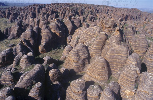 AUSTRALIA, Western Australia, Bungle Bungles, View over rounded rock towers striped in alternate bands of orange silica and black lichen.