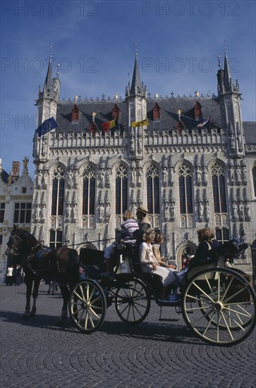 BELGIUM, West Flanders, Bruges, Tourist horse and carriage outside the Stadhuis in Burg Square