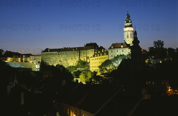 CZECH REPUBLIC, South Bohemia, Cesky Krumlov, View of the Chateaux and Round Tower illuminated at night.