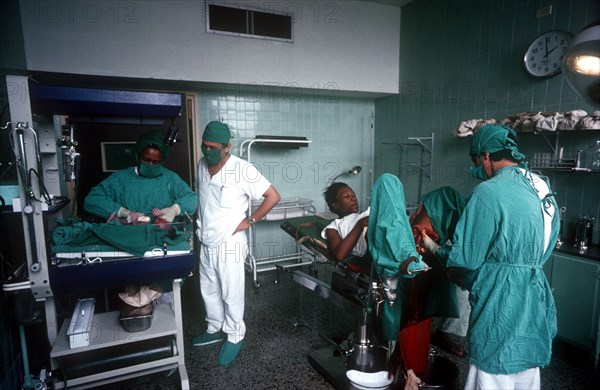 CUBA, Havana, Maternity Hospital, Doctors and nurses with a mother who has just given birth and her newborn baby is being weighed