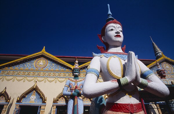 MALAYSIA, Penang, Georgetown, "Wat Chayamangkalaram.  Exterior, temple statues with part view of rooftop and facade behind."