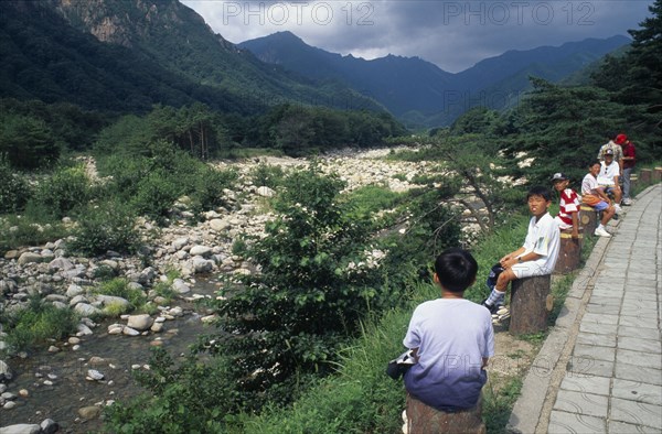 SOUTH KOREA, Soraksan Nat. Park, Sorak Mountains, Ssang-Chon River.  Children sitting beside almost dry river bed