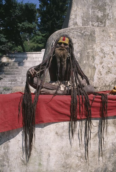 NEPAL, Kathmandu Area, Portrait of a Saddhu with excessively long hair sitting outside Pashupatinath Temple