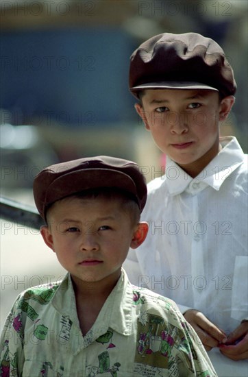CHINA, Xinjiang, Kashgar, Portrait of two yound boys wearing caps